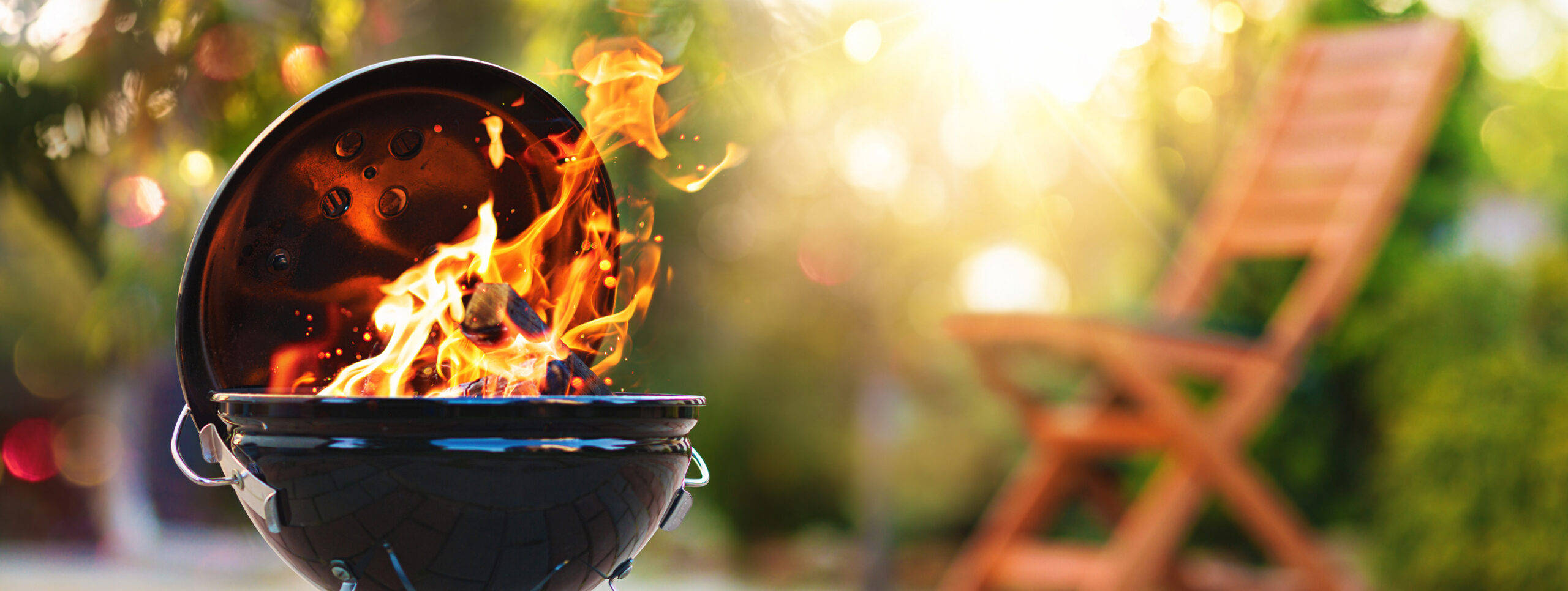 Charcoal grill with open flames in a backyard