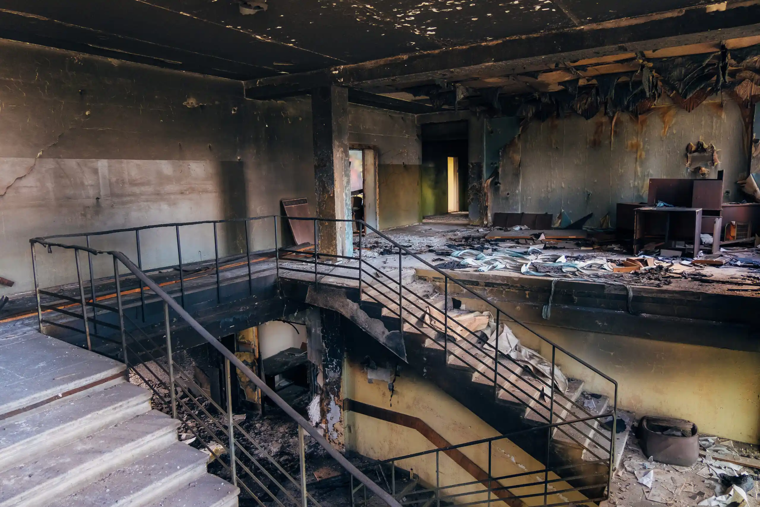 Smoke-blackened walls and staircase showing extensive soot damage requiring professional restoration
